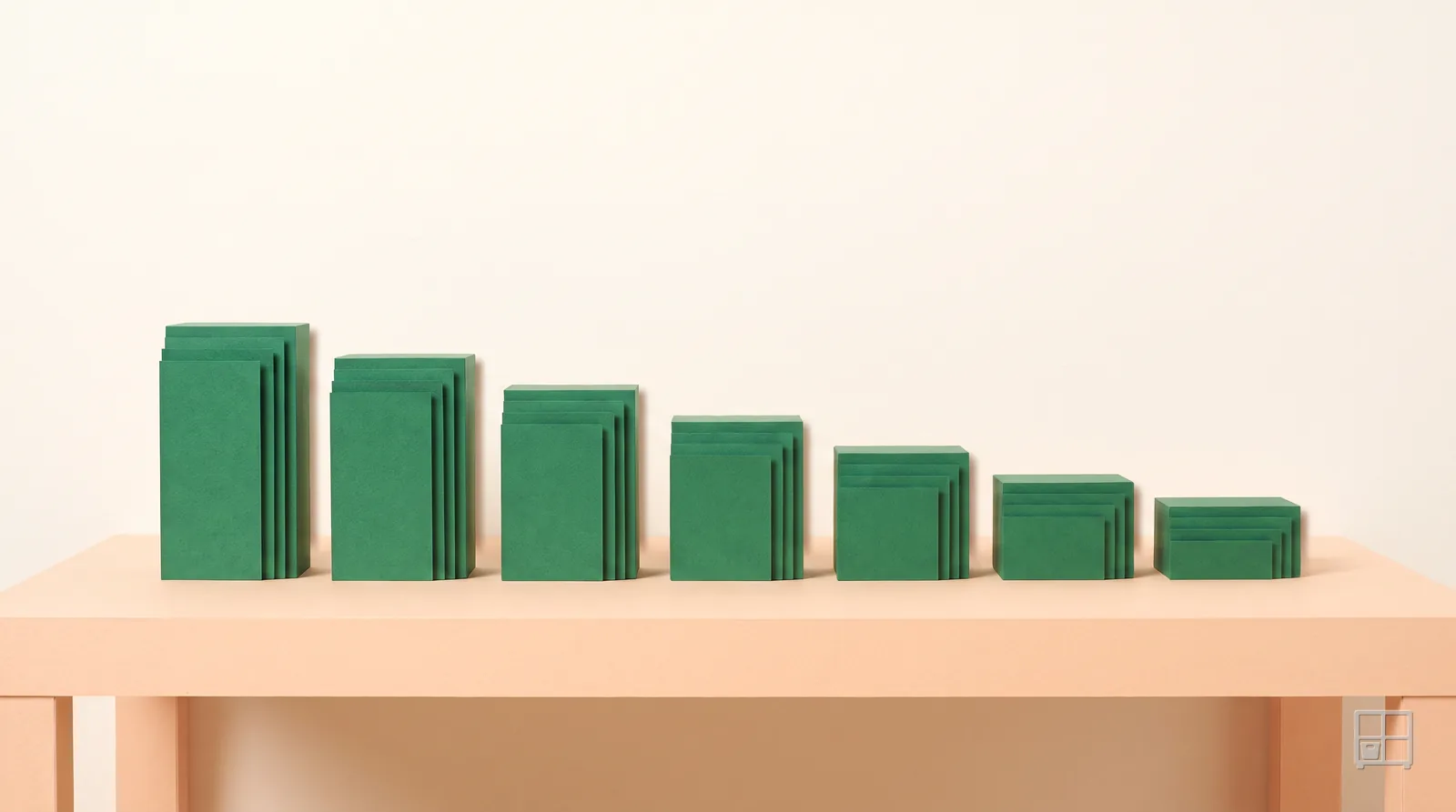 Cut-paper collage of seven stacks of green sheets on a table, each stack shorter than the one before it