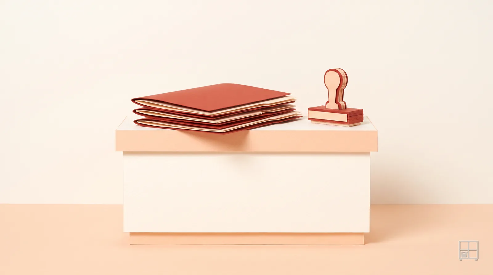 Cut-paper collage of a stack of red sheets and a rubber stamp on a pale counter